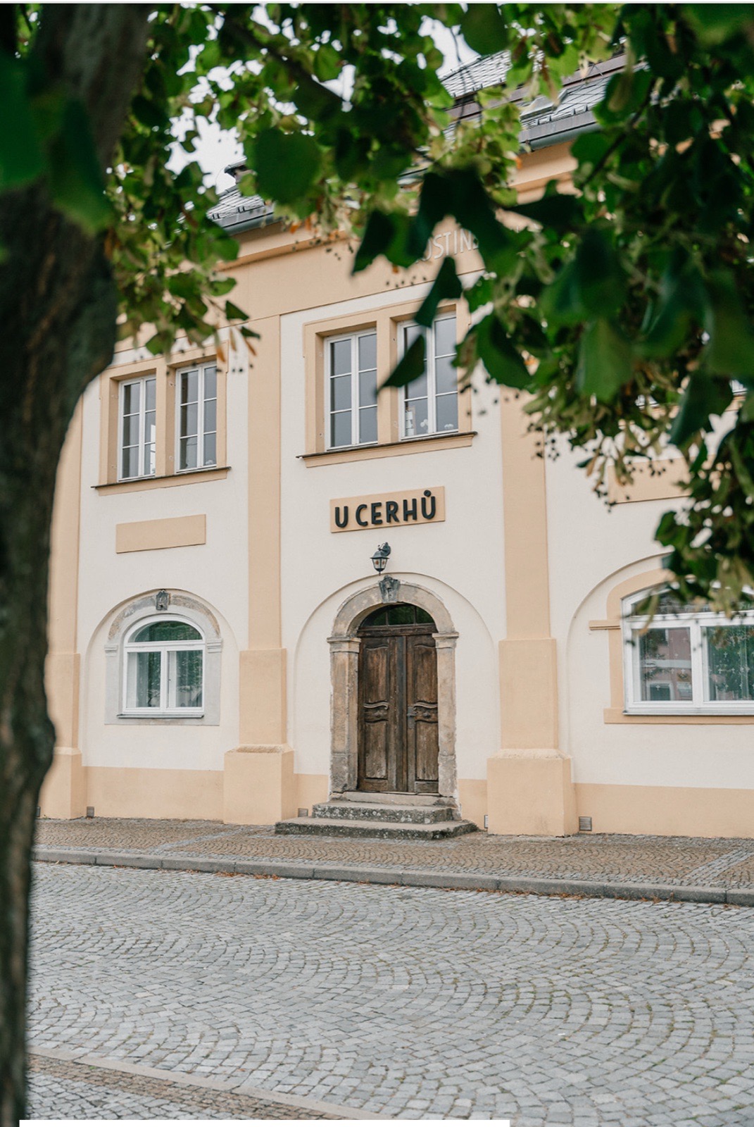 Historická budova statku U Cerhů v Kněžmostě – fasáda s nápisem na kamenném náměstí Českého ráje